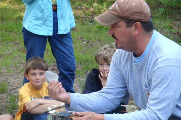 Eric Drake, USFS archaeologist, demonstrates flint knapping, on Grand Island.