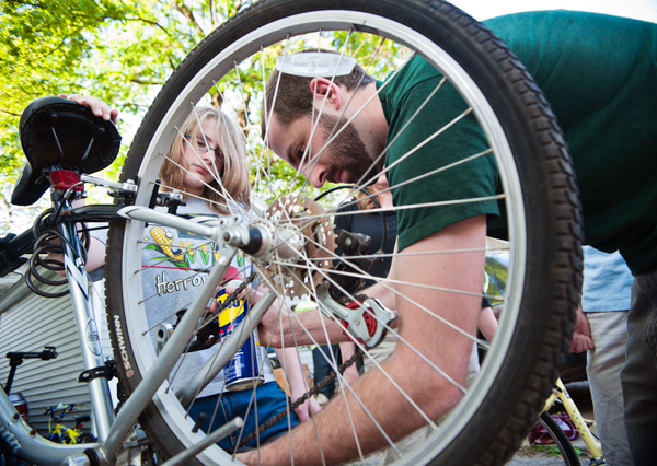 James Clemons, 14, learns to clean and oil a chain with Open Roads volunteer Sean Walker.